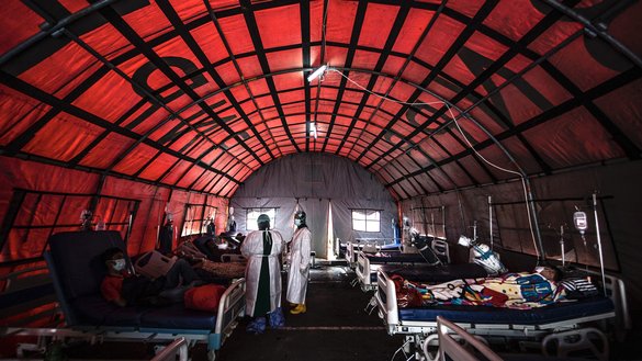 Medical personnel tend to COVID-19 patients in a tent set up outside a hospital in Bogor on June 29, as infections soar in Indonesia. [Aditya AjiAFP]