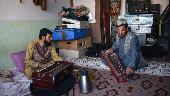 Professional musician Sayed Mohammad (right) rehearses with his japani, a traditional Central Asian stringed instrument, along with harmonium player Ghulam Mohammad at Sayed's music studio in Kandahar on June 8. [Javed Tanveer/AFP]