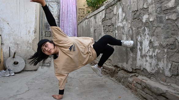 Manizha Talash, the only female member of a group of break-dancers comprised of mostly Hazara boys, practices a move in Kabul on June 12. [Adek Berry/AFP]