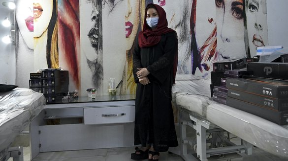فریده یک آرایشگر به تاریخ ۲۰ جوزا در آرایشگاه خود در کابل برای عکس گرفتن آماده می شود. [ادیک بیری/ای اف پی]