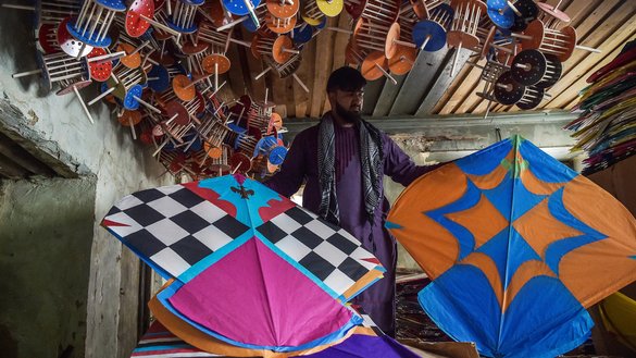 A kite vendor shows his merchandise inside a warehouse in Shor Bazaar in the old quarters of Kabul on June 9. [Wakil Kohsar/AFP]