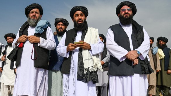 ذبیح الله مجاهد سخنگوی طالبان (وسط) به تاریخ ۹ سنبله در میدان هوایی کابل با رسانه ها صحبت می کند. [وکیل کوهسار/ای اف پی]