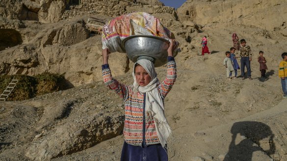 په دې عکس کې چې د تلې په ۳مه اخیستل شوی، هزاره ماشومان په بامیان کې، هغو ګړنګونو ته نږدې چې افغانان د پیړیو پخوا په څیر اوس هم پکې ژوند کوي، له خپل کلي څخه سین ته روان دي. [بولینټ کیلیک/ای اېف پي]