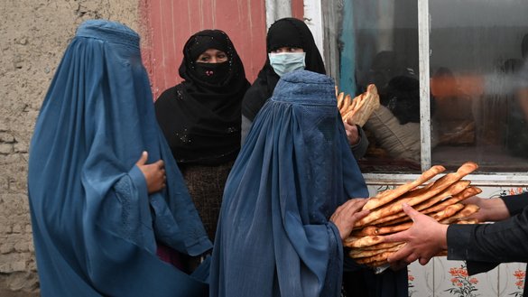 زنان به تاریخ ۲۸ جدی نان رایگان را دریافت می کنند که به عنوان بخشی از کمپاین «افغان ها را از گرسنگی نجات دهید» در پیش روی یک نانوایی در کابل توزیع می شود. [وکیل کوهسار/ای اف پی]