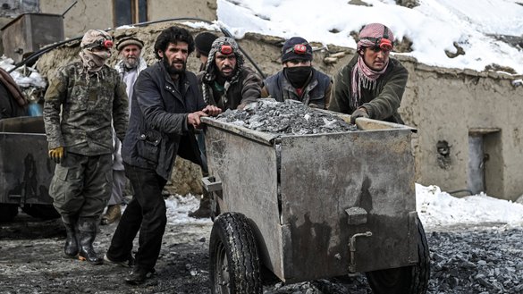 Workers push a cart filled with raw stones before sorting out emeralds on a mountain towards the mining area in the Mikeni Valley, Panjshir province, on January 12. [Mohd Rasfan/AFP]
