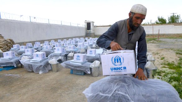 An internally displaced man carries aid he received from the UNHCR in Mazar-e-Sharif, Balkh province, April 22. [Balkh Refugees and Repatriations Department]