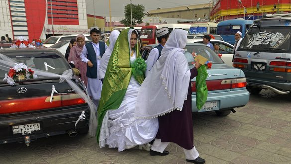 یک زوج افغان سالون عروسی را بعد از پایان مراسم ازدواج گروهی که به تاریخ ۲۳ ماه جوزا در کابل برگزار شد ترک می کنند [ساحل آرمان/ای اف پی]