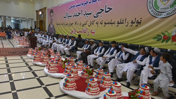 Grooms sit inside a wedding hall as they wait for the start of a mass marriage ceremony in Kabul on June 13. [Sahel Arman/AFP]