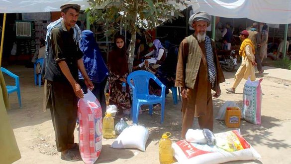 Needy Afghans receive food packages from the US Agency for International Development (USAID) with support from the World Food Programme (WFP) in Taloqan, capital of Takhar province, July 23. [Takhar Rural Rehabilitation and Development]