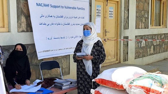 In this undated photo, employees of the Norwegian Afghanistan Committee (NAC) provide food supplies to needy women in Badakhshan province. [Courtesy of NAC]