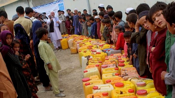 Residents of Badguzar village in Ishkamish district, Takhar province, wait in line for drinking water that is provided by the UNICEF in the area on August 26. [Takhar Directorate of Rural Rehabilitation and Development]
