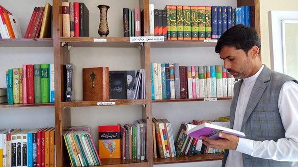 مردی به تاریخ ۲۳ سنبله در کتابخانه جدید کتاب سرای اورانوس که توسط یک زن جوان افغان در فیض آباد، مرکز ولایت بدخشان، تأسیس شده است، کتاب ها را بررسی می کند. [عکس از گیتی فرح]