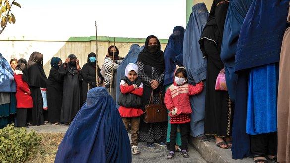 Women wait in a queue during a World Food Programme (WFP) cash distribution event in Kabul on November 29, 2021. [Hector Retamal/AFP]