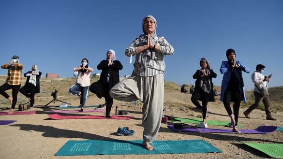 دو سال پیش، زنان افغان می توانستند به طور آشکار یوگا تمرین کنند. فخریه ممتاز، مربی ۴۳ ساله (وسط) و مؤسس اولین مرکز یوگا در کابل برای زنان، به تاریخ ۱ سرطان سال ۱۳۹۹ در یک جلسه یوگا در روز جهانی یوگا در بالای تپه شهرک حاجی نبی در حومه کابل شرکت می کند. [وکیل کوهسار/ای اف پی]