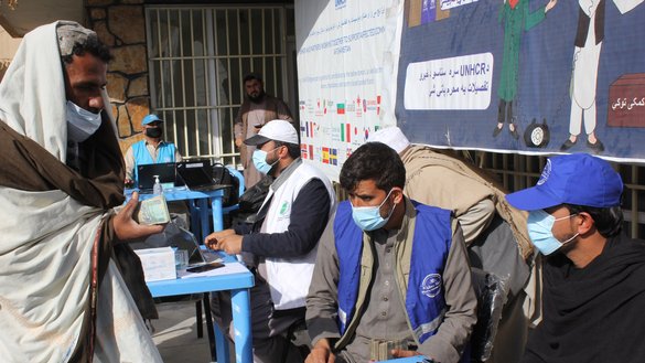 A man (left) receives cash assistance from United Nations High Commissioner for Refugees (UNHCR) local workers in Kandahar city on February 2. [Rahimullah Khpelwak/Salaam Times]