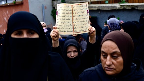 A protester holds a copy of the Qur'an during a demonstration in Istanbul on January 22, after a far-right politician burned a copy of the holy book near the Turkish Embassy in Stockholm. Media reports suggest Russia had a hand in the incident, which has stalled Sweden's NATO bid. [Yasin Akgul/AFP]