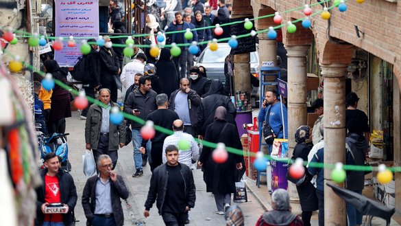 People walk in a commercial area in Tehran on February 21. [ATTA KENARE / AFP]