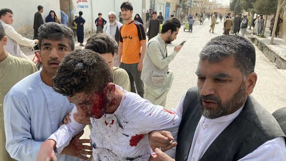 A wounded man is assisted near the site of an ISIS attack during an event commemorating the media in Mazar-e-Sharif on March 11. [Atif Aryan/AFP]