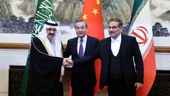 وانگ یی، رئیس دفتر کمیسیون مرکزی روابط خارجی چین به تاریخ ۱۹ حوت در بجینگ، با علی شمخانی، منشی شورای عالی امنیت ملی ایران و موساد بن محمد آل ایبان، مشاور امنیت ملی عربستان سعودی، برای عکس گرفتن ایستاده است. [وزارت خارجه چین]