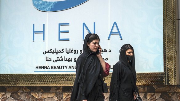 Women walk past a beauty salon at the Shahr-e Naw area in Kabul on July 4. [Wakil Kohsar/AFP]
