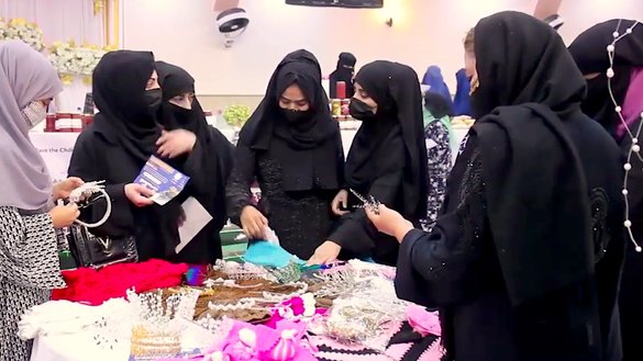 Women examine handicrafts at an exhibition in Sheberghan, Jawzjan province, July 27. [Courtesy of Atiqullah Ibrahimzada]