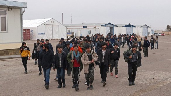 In this photograph taken on February 12, a group of Afghan immigrants who were deported back from Iran to Afghanistan, walk at the Islam Qala border between Afghanistan and Iran in Herat province. [Mohsen Karimi/AFP]