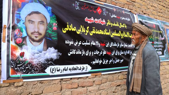 پدری بتاریخ ۱۱ قوس یک روز پس از کشته شدن پسرش توسط تروریست ها، در شهر هرات به عکس او نگاه می کند. [عمر/سلام تایمز]