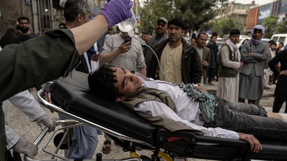 Medical staff move a wounded youth outside a hospital in Kabul on April 19, 2022, after two bombs rocked a boys' school in a Shia Hazara neighborhood, killing at least 6 people. [Wakil Kohsar/AFP]