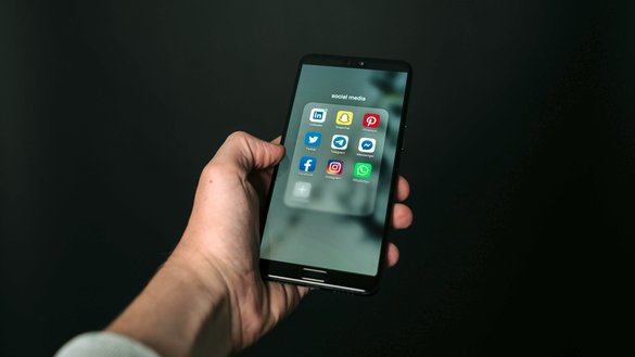 یو سړي موبایل ټلیفون چې د ټولنیزو رسنیو اپلیکېشنونه ښيي، په لاس کې لري. [پیکسلز/مګنس مولر]