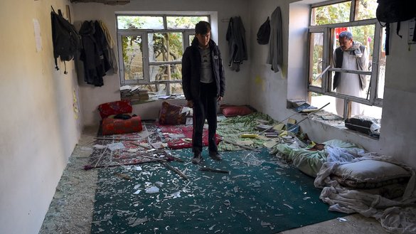 A student stands near the scene of an ISIS-K suicide attack on the Kawsar-e-Danish education center in Kabul on October 25, 2020, a day after the attack. [Wakil Kohsar/AFP]