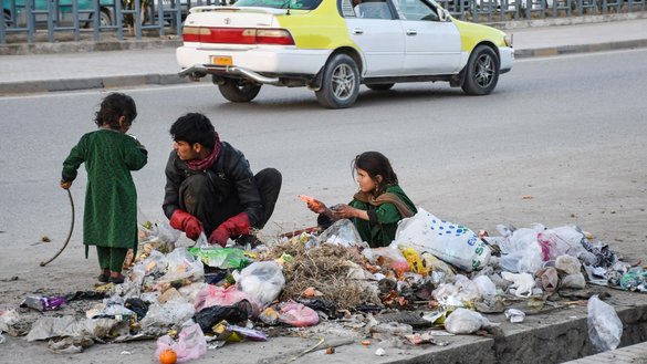 یک مرد افغان همراه با دو دختر خوردسال به تاریخ ۲۷ دلو ۱۴۰۳خورشیدی کثافات ریخته شده در کنار جاده‌ای در مزار شریف را جمع‌آوری می‌کند. [عاطف آرین/خبرگزاری فرانسه]