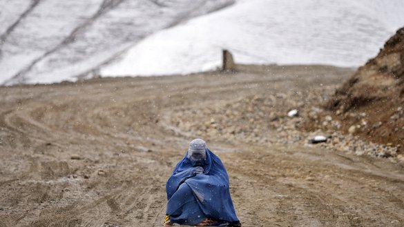 د کب په ۱۳مه د بدخشان ولایت په ارګو ولسوالۍ کې د واورې اورښت پرمهال یوه افغانه ښځه د سرک پر غاړه خیرات غواړي. [عمر ابرار/ای اېف پي]