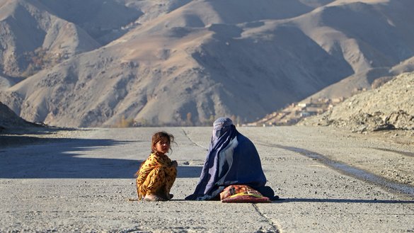 به تاریخ ۲۵ عقرب ۱۴۰۲ خورشیدی یک زن با برقع در کنار دختری نشسته و در کنار یک سرک در فیض اباد، ولایت بدخشان خیرات جمع می کند. [عمر ابرار/خبرگزاری فرانسه]