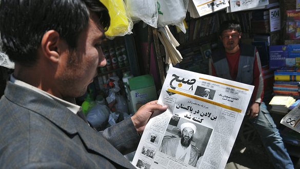یک مرد افغان بتاریخ ۱۳ ثور ۱۳۹۰ خورشیدی در کابل روزنامه‌ ای را می‌ خواند که خبر مرگ اسامه بن لادن، رهبر القاعده را منتشر کرده است. [مسعود حسینی/خبرگزاری فرانسه]